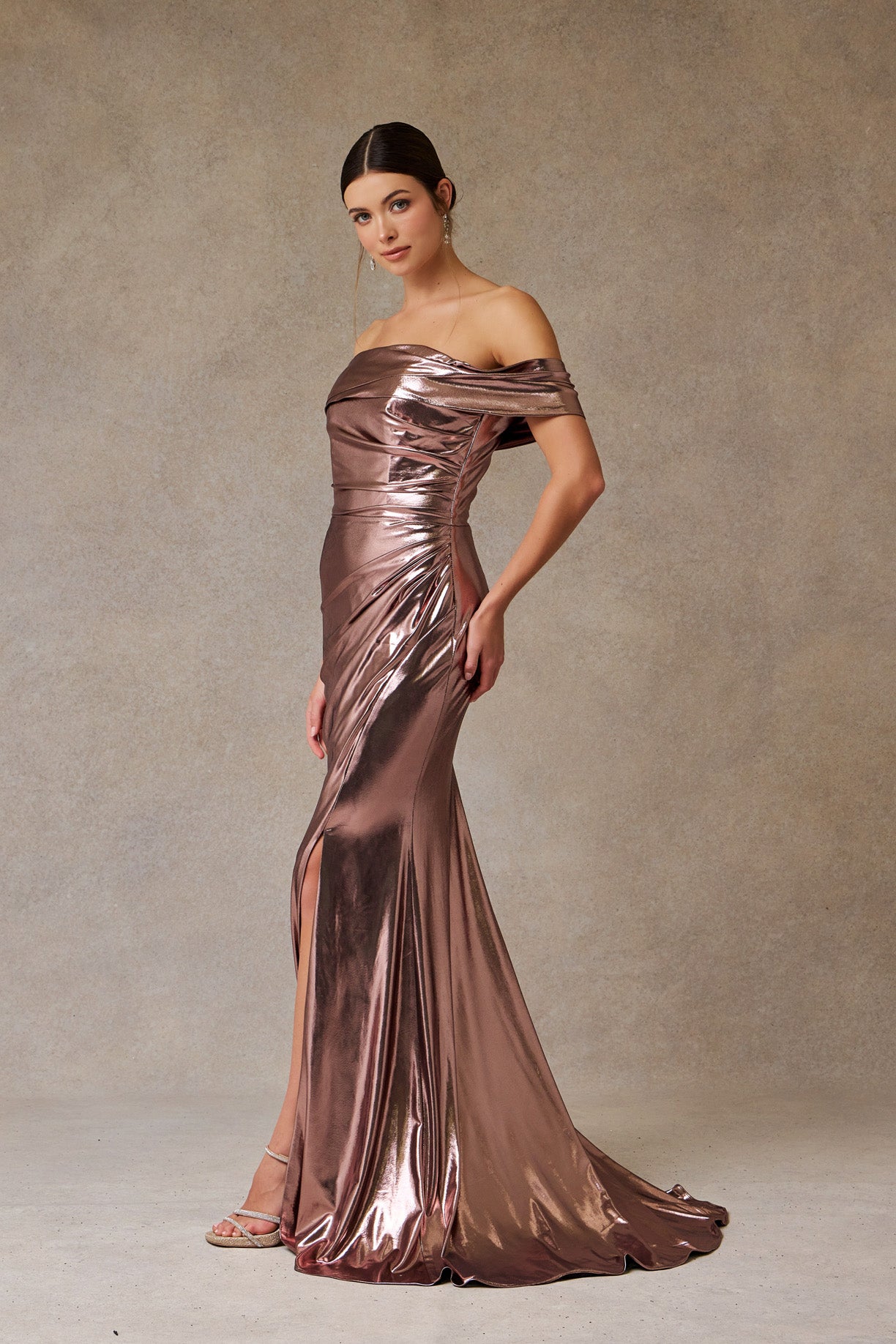 Vestido Corte Sirena Metalizado con Hombros Descubiertos y con Abertura en la Pierna Color Bronze.