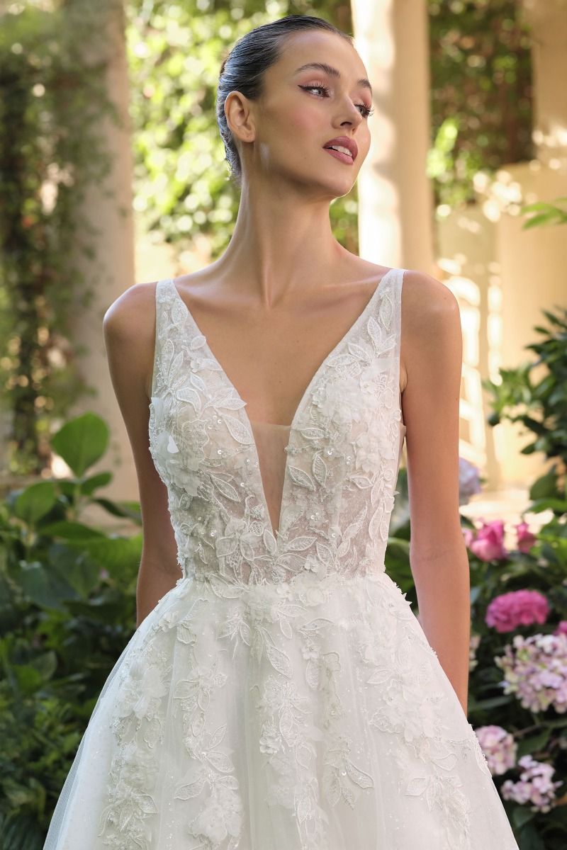Vestido de Novia Escote en V profundo, tirantes finos y aberturas laterales transparentes.