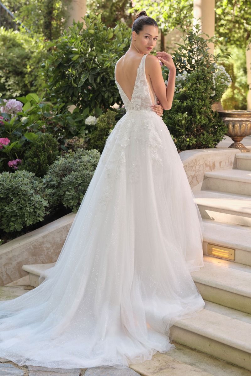 Vestido de Novia Escote en V profundo, tirantes finos y aberturas laterales transparentes.