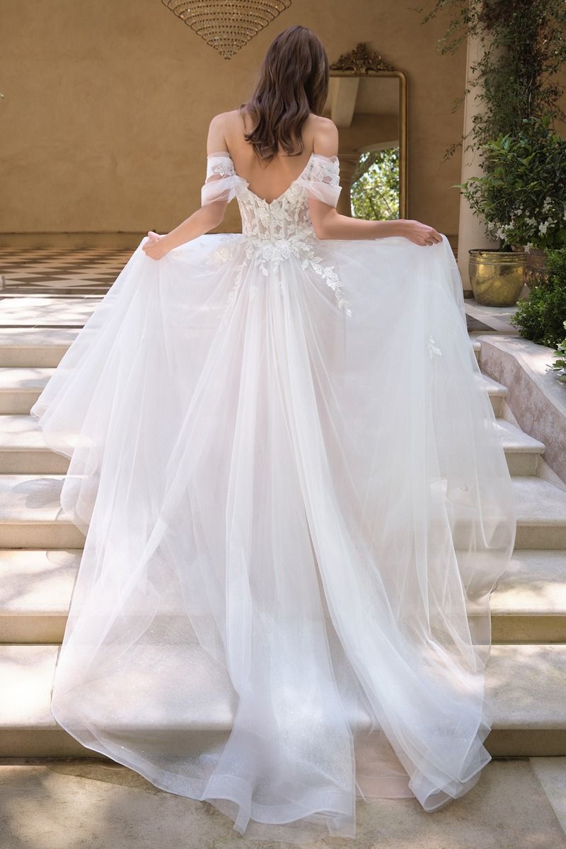 Vestido de Novia Escote ilusión con hombros descubiertos, apliques florales y mangas drapeadas transparentes.